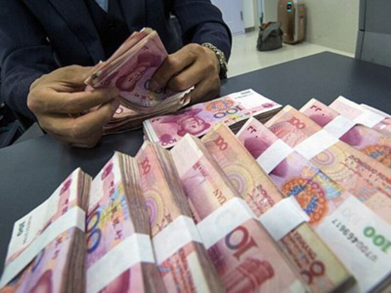A Chinese clerk counts renminbi yuan banknotes at a bank in Nantong, east China's Jiangsu province, May 23, 2016.