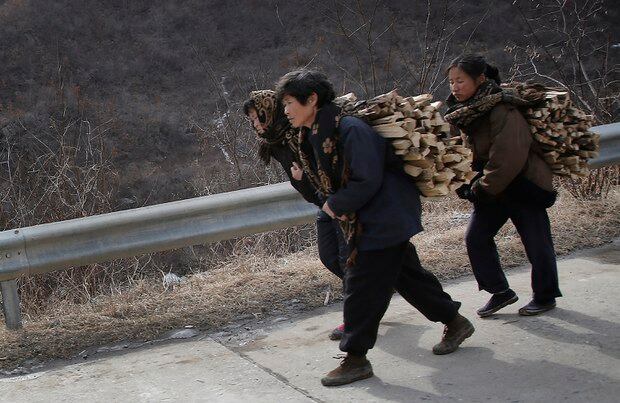 황해북도 신평군에서 등에 지게를 지고 걷고 있는 북한 여성들.