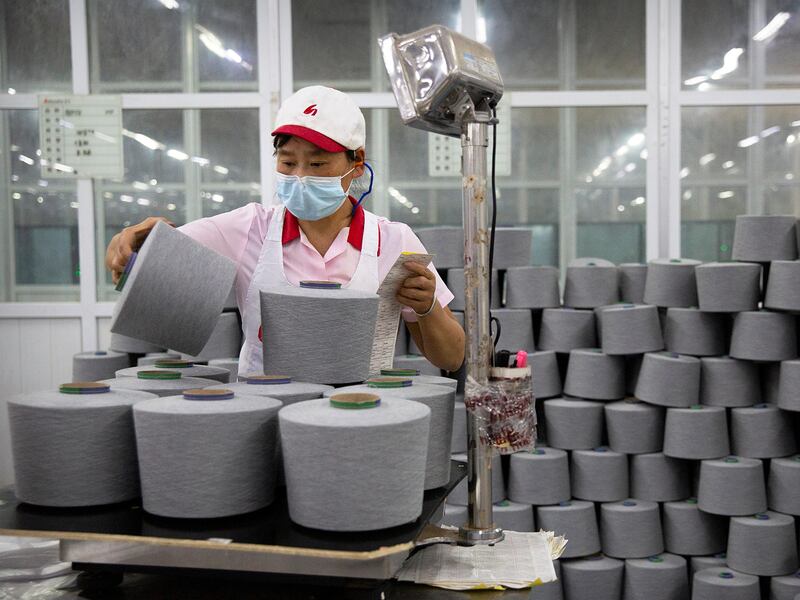 A worker packages spools of cotton yarn  in an Aksu factory in China's Xinjiang Uyghur Autonomous Region,  April 20, 2021.