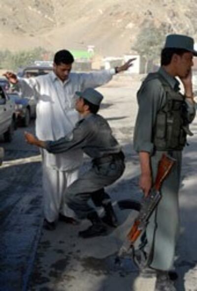Cảnh sát Afghanistan đang khám một người dân tại một trạm kiểm soát ở Kabul (2009/AFP)