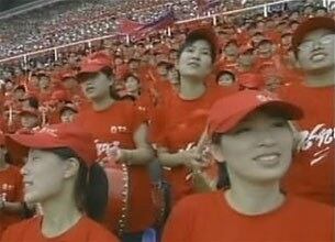 2009년 6월 북한 조선중앙TV를 통해 생중계된 2010 남아프리카공화국 월드컵 아시아 최종예선 B조 북한 대 이란 경기중 여성응원자들이 '강성대국'이라는 글씨가 씌어진 붉은 상의를 입고 북을 치며 북한팀을 응원하고 있다.