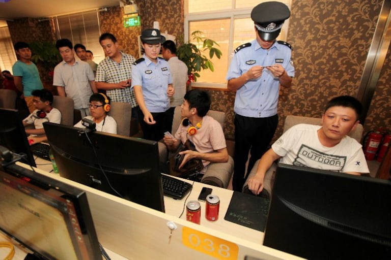 Police check the ID cards of netizens at an internet cafe in Shandong, China, in a file photo.