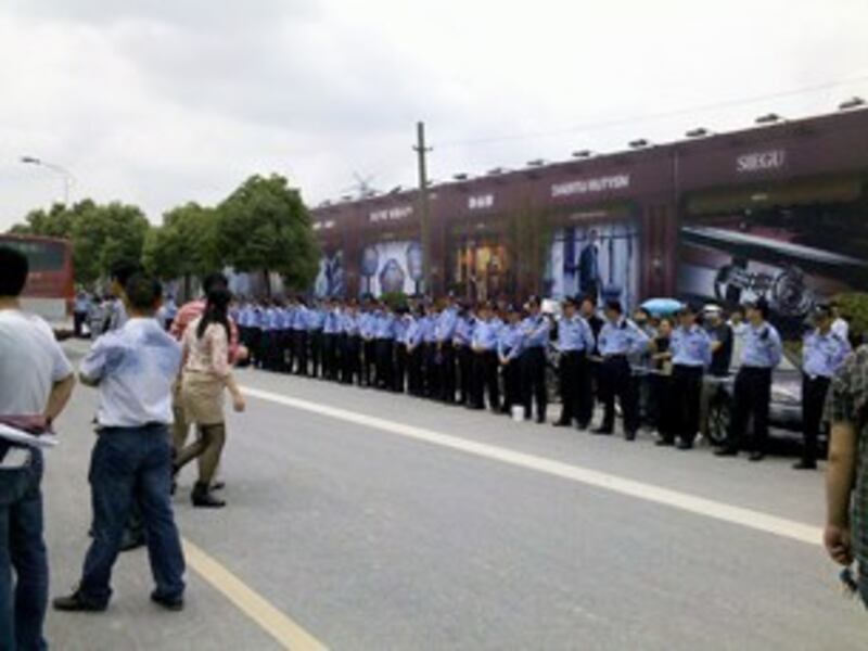 图片：警察在万达广场外筑起人墙。（中国茉莉花革命网站）