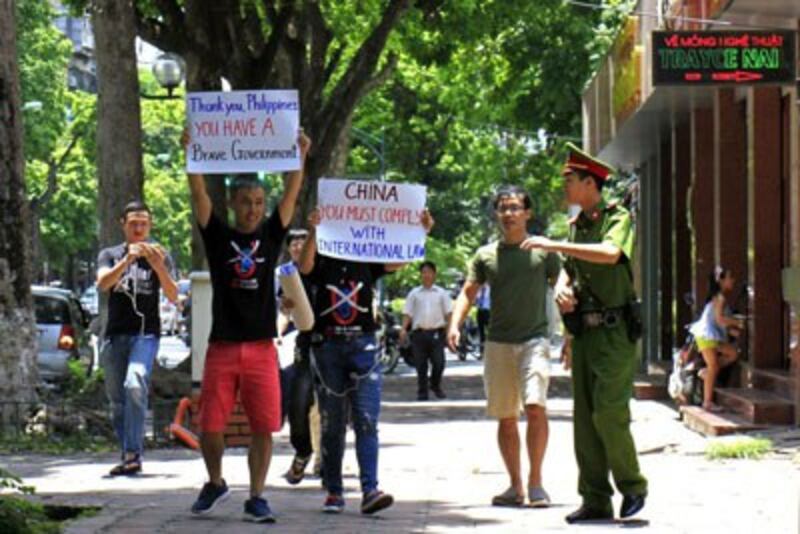 Một công an ngăn cảnh người dân biểu tình chúc mừng chiến thắng của Philippines trước Trung Quốc về phán quyết biển Đông hôm 17/7/2016. AFP photo