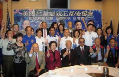 图片：国民党海外干部藉授旗拉抬党员求胜士气。(萧融摄)