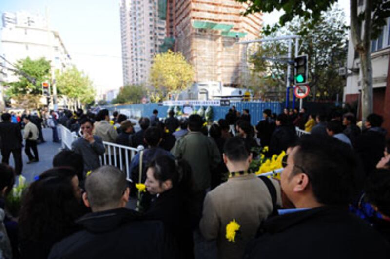 2012年11月15日,數百災民以及市民,手持菊花來到大火現場進行悼念。(王先生 提供)