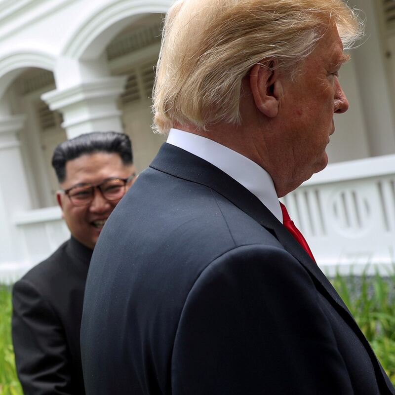 U.S. President Donald Trump and North Korea's leader Kim Jong Un walk together during their summit at the Capella Hotel on the resort island of Sentosa, Singapore, June 12, 2018. (Reuters)