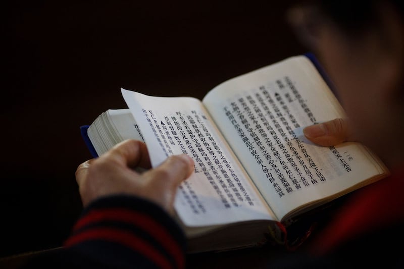 2018年10月1日，一名天主教信徒在中国北京的政府认可的圣若瑟堂参加弥撒时阅读圣经。（路透社）