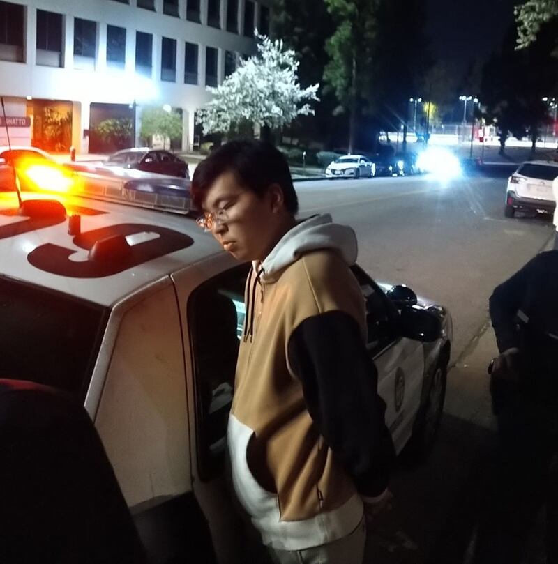 一个疑似小粉红的中国留学生模样的年轻人，踢倒摆放的花圈，并拉扯活动投影幕布。当时几个人一边抓住他一边呼叫警察，警察很快过来将他拷上，搜身时发现一把折叠刀。(界立建提供)