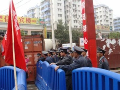 图片:警察架起塑料防护栏,周日晚间被烧毁(业主拍摄并发上网)
