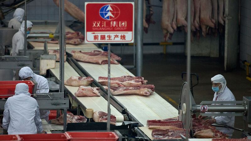目前中国的生猪调配范围普遍在300公里以内，猪肉的价格受地域影响较大，不少地区的猪肉零售价格涨幅接近30%。图为，河南双汇集团有限公司，员工在猪肉加工厂工作。（AFP）