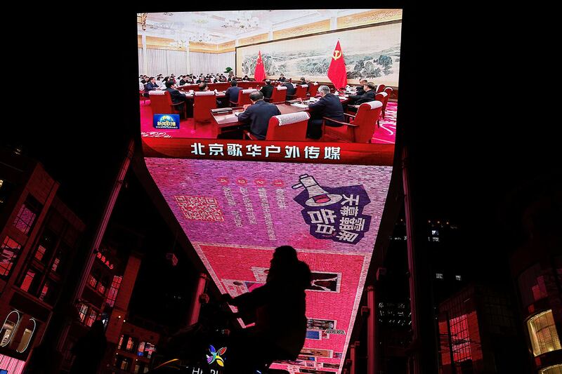 2024年12月9日，北京一块巨型屏幕播放中国国家主席习近平出席中共中央政治局会议的新闻画面。