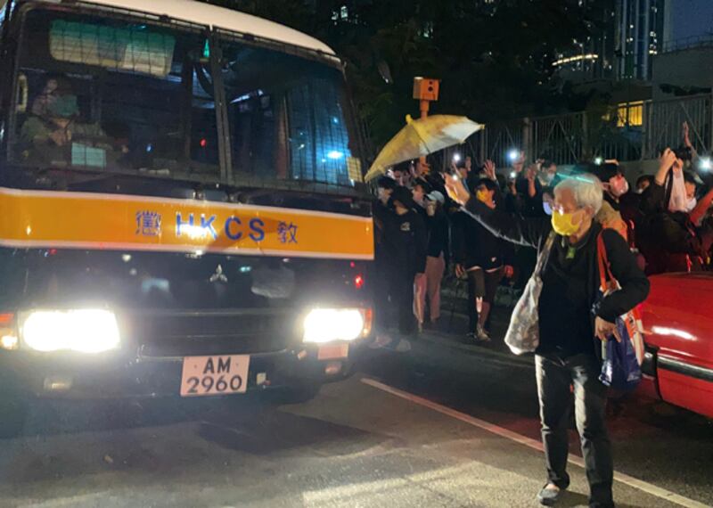 2020年12月2日，王婆婆以黃傘擋在囚車前。（劉少風 攝）