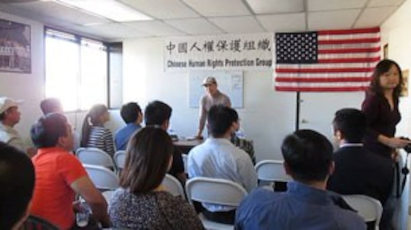 图片:座谈会疑有“海外五毛”(图右持相机女子)到场工作,频频对与会者近距离拍照摄像。 ( 主办方提供)