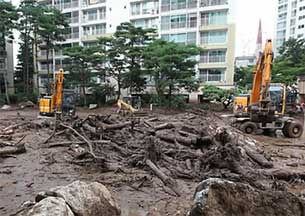 우면산 산사태 피해를 크게 입은 서울 방배동 한 아파트단지에서 지난해 8월 인부들이 중장비를 이용해 토사 제거작업을 하고 있다.