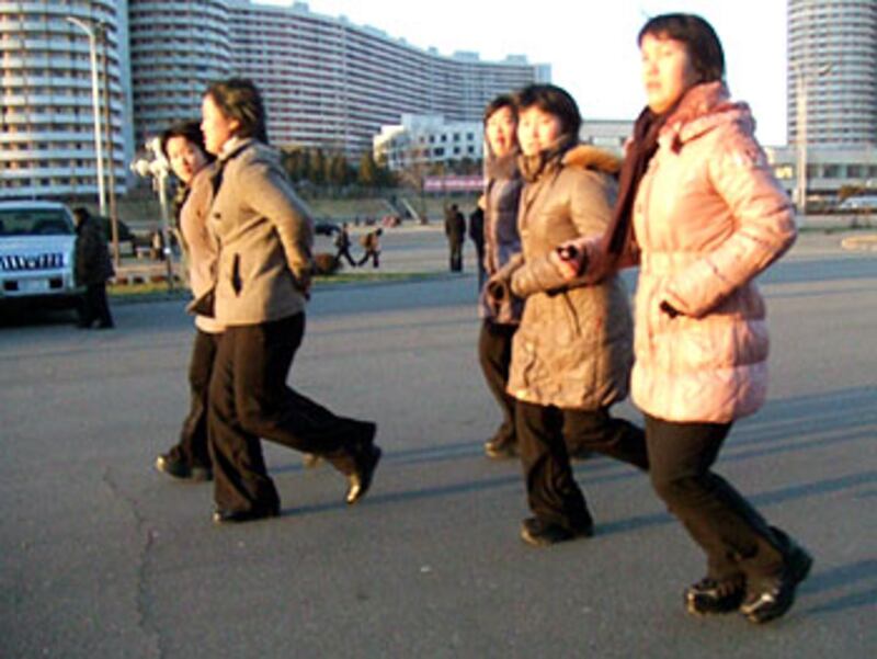 圖片1和11:時值12月,平壤的氣溫寒冷,但在主要街道千里馬大街上,仍然有不少民眾一早出來散步,不過他們對陌生人相當戒備,一般不會主動攀談。記者幸運地問到一名當地市民,他表示,平壤一般百姓現在的月收入大約是7000北韓元,儘管官方指北韓元和人民幣的匯率是16比1,但這個數目實際上只等於人民幣20元左右。他悄悄對記者說,物價是朝鮮的國家機密,官方公佈的匯率只是用來欺騙外國人。不過他指,現在的情況已經比1996年大饑荒時好很多。