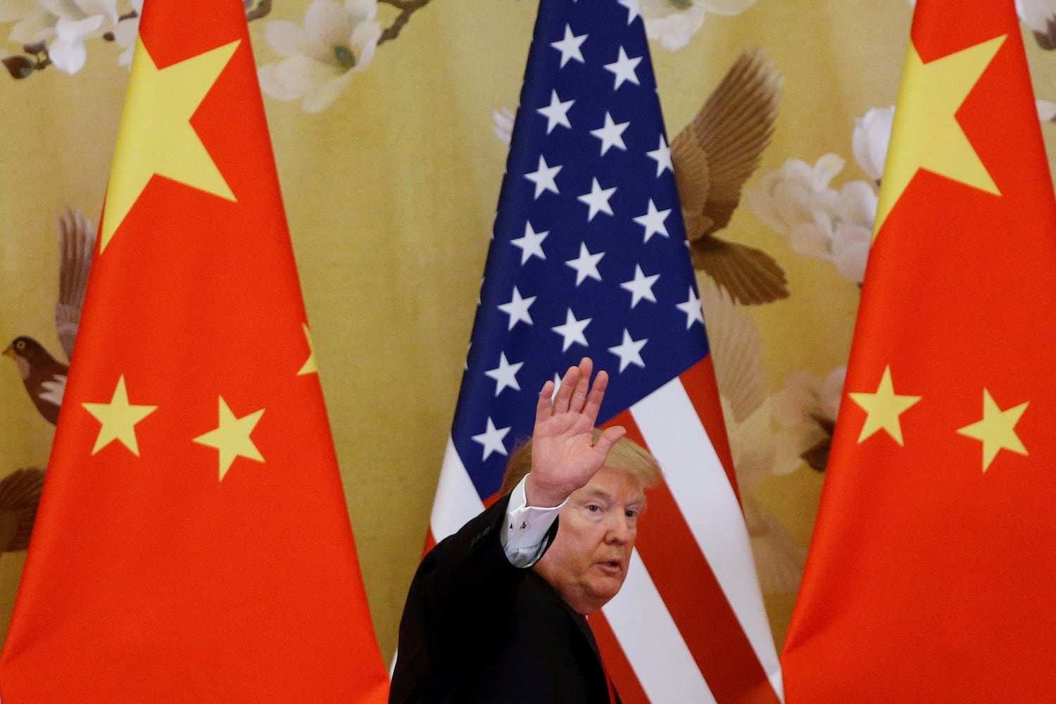 President Donald Trump waves during joint statements with China's President Xi Jinping at the Great Hall of the People in Beijing, Nov. 9, 2017.