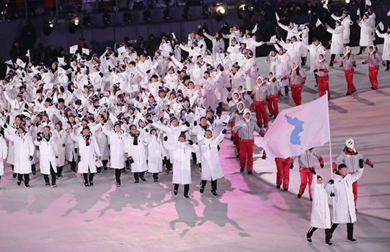 강원도 평창 올림픽스타디움에서 열린 2018 평창동계올림픽 개막식에서 남북 선수단 공동기수인 남측 원윤종, 북측 황충금이 한반도기를 앞세우고 동시 입장하고 있다.
