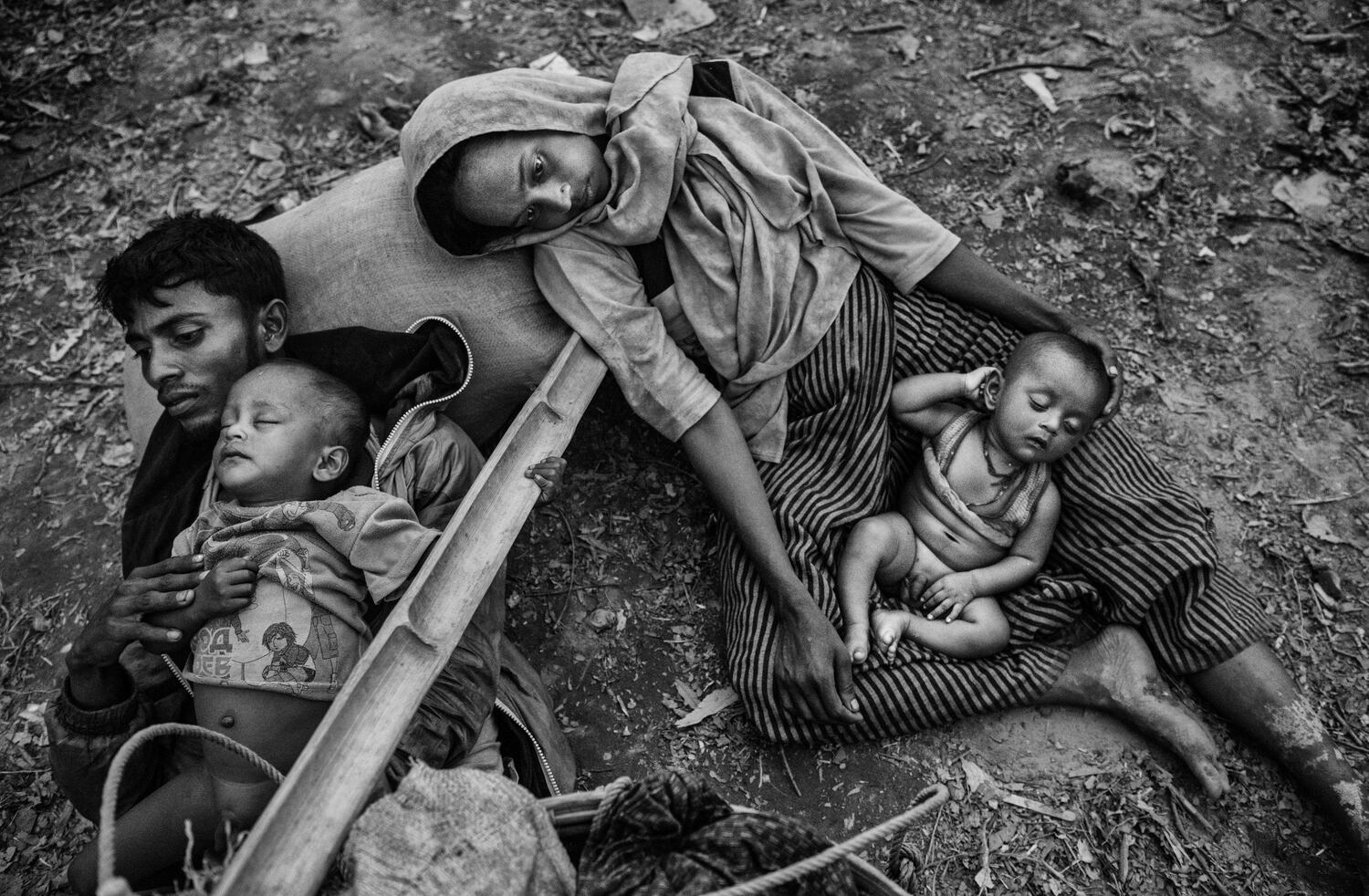 Los refugiados rohingya Minara Hassan y su esposo Ekramul yacían en el suelo en el lado bangladesí del río Naf en Cox's Bazar, Bangladesh, el 2 de octubre de 2017, después de huir de su hogar en Maungdaw, Myanmar. (Kevin Frayer/Getty Images)
