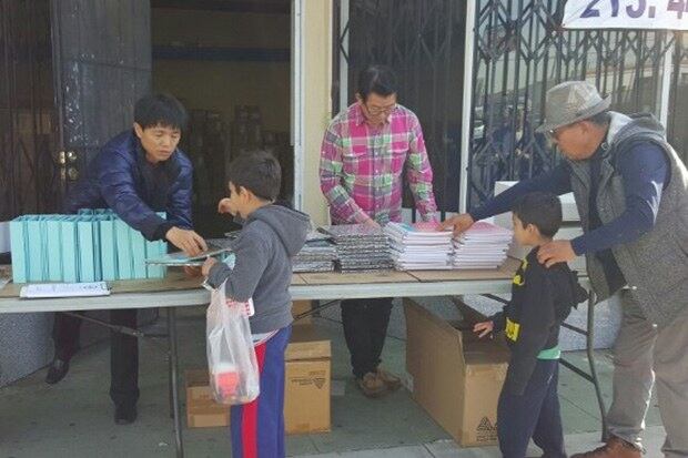 엔키아 소속 탈북자들이 저소득 가정 아이들에게 학용품을 나눠주고 있다.  