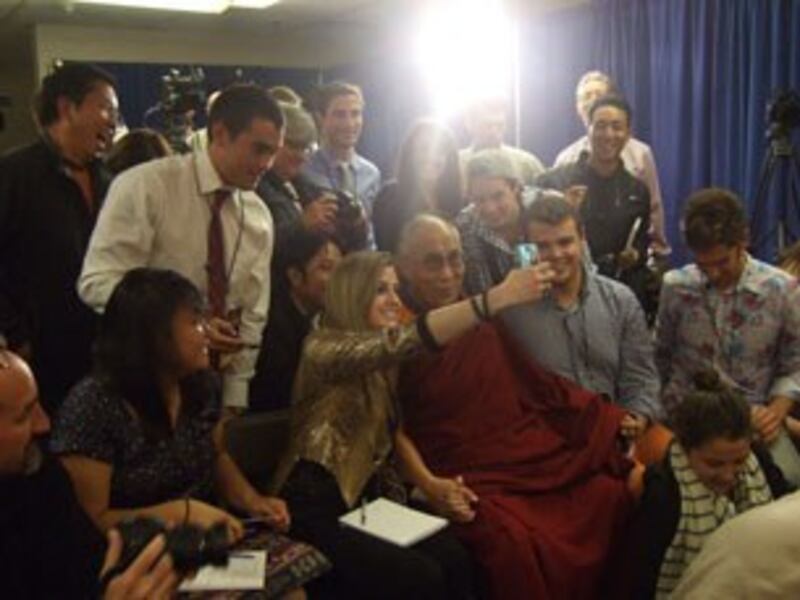 图片：达赖喇嘛坐到记者中间合影。（紫荆摄）