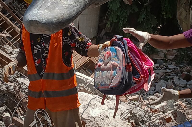 Workers retrieve children's belongings at a pre-school in Sagaing city, Myanmar, on April 24, 2025, four weeks after Myanmar's devastating earthquake.