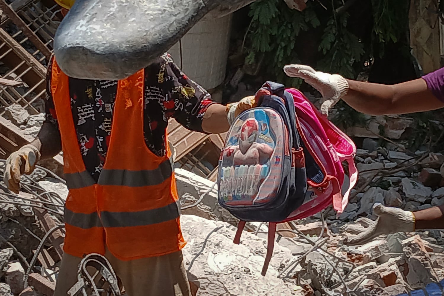 Workers retrieve children's belongings at a pre-school in Sagaing city, Myanmar, on April 24, 2025, four weeks after Myanmar's devastating earthquake.