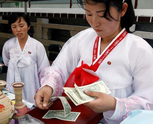 개성에서 한 여성이 달러를 계산하고 있다.