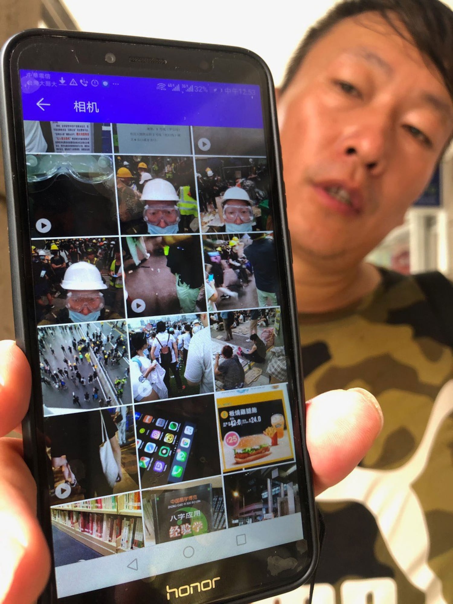 张文出示他手机里存有部份参与香港反送中的照片和视频。(记者夏小华摄)