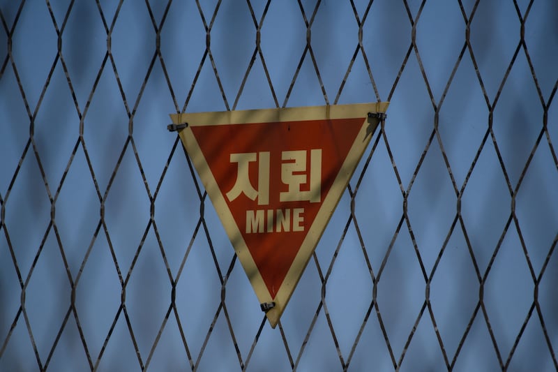 비무장지대(DMZ) 철책에 지뢰 위험을 알리는 경고 표지판이 설치돼 있다.