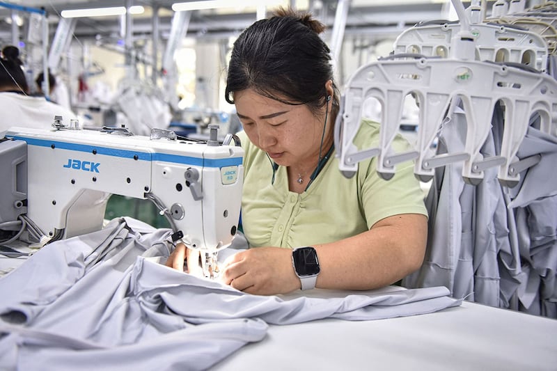 2024年6月27日,安徽阜阳的一家工厂,工人正在生产防晒服装。(法新社)