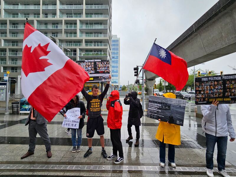来自不同族裔的年轻人冒雨在列治文市街头声援民主，谴责中共暴政。 (记者柳飞拍摄)