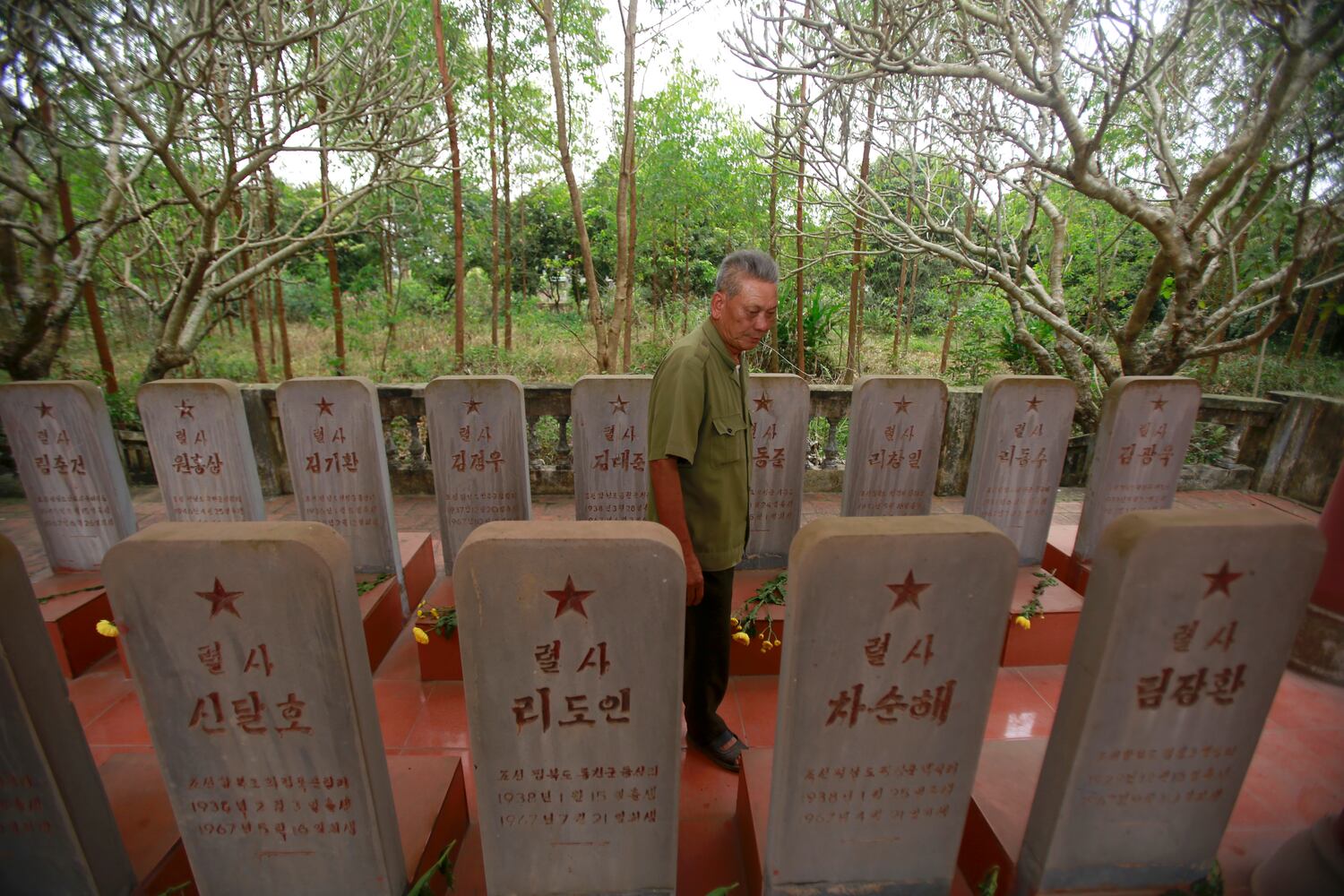In this Feb. 16, 2019, photo, war veteran Duong Van Dau walks in between a row of headstones at a memorial for North Korean fallen pilots in Bac Giang province, Vietnam.