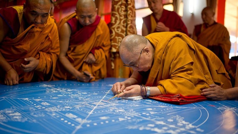 His Holiness the Dalai Lama placing the first grains of colored sand to start the construction of the Kalachakra sand mandala during the 32nd Kalachakra Empowerment in Bodhgaya, Bihar, India on January 1, 2012. Credit: Tenzin Choejor/OHHD