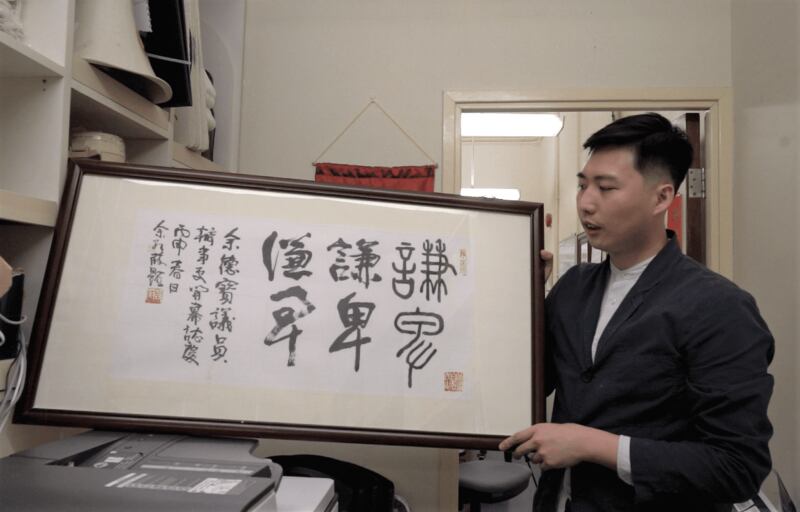 余德寶拿起公民黨前黨魁余若薇送給他的牌匾。(張展豪攝)