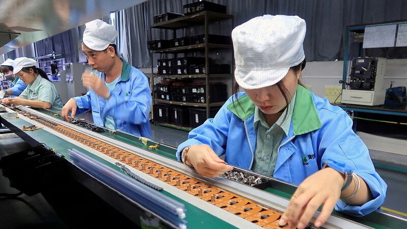2021年12月30日,广东省东莞市一家工厂,员工在为美国公司 T2M 的移动游戏控制器生产线工作。(路透社)
