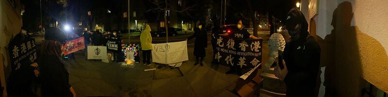 在旧金山中领馆前的追思会现场，活动参加者们围绕着蜡烛、鲜花与连侬墙，对梁凌杰进行悼念。（孙诚拍摄，独家首发）