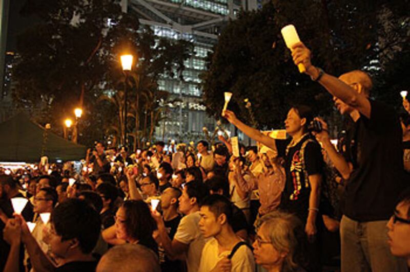 6月13日，香港市民手持洋燭和菊花悼念李旺陽。（粵語部記者文宇晴攝）