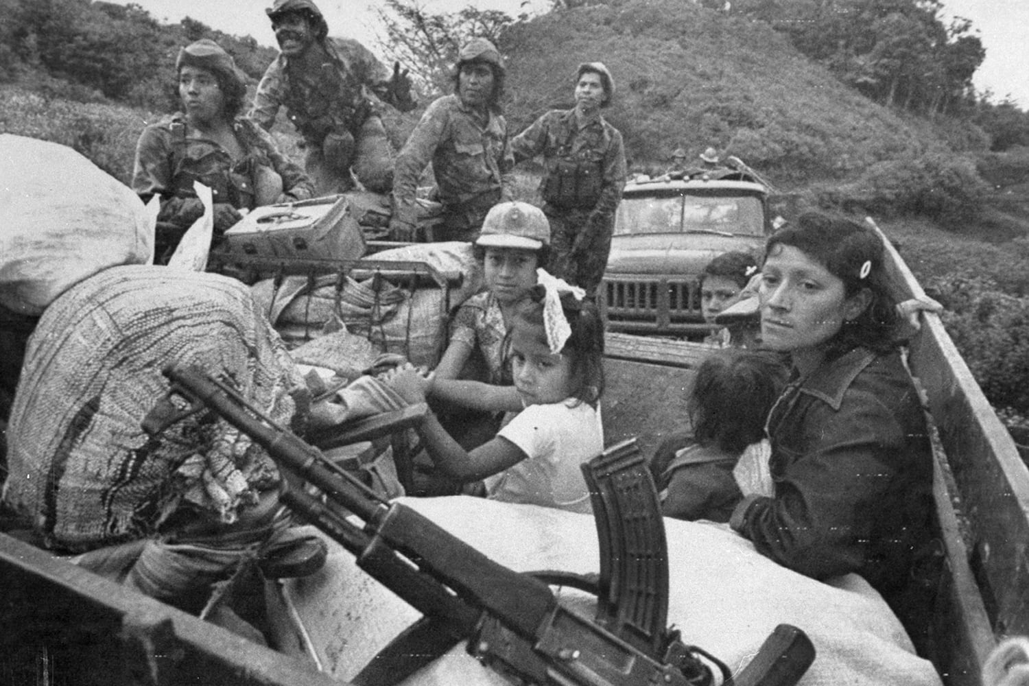 A Khmer Rouge father and his daughter ride in a truck near a refugee camp as Vietnamese forces attack Phnom Malai, Feb. 20, 1985.