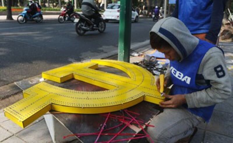 Công nhân với biểu tượng búa liềm trang trí thành phố Hà Nội vào năm mới. AFP photo