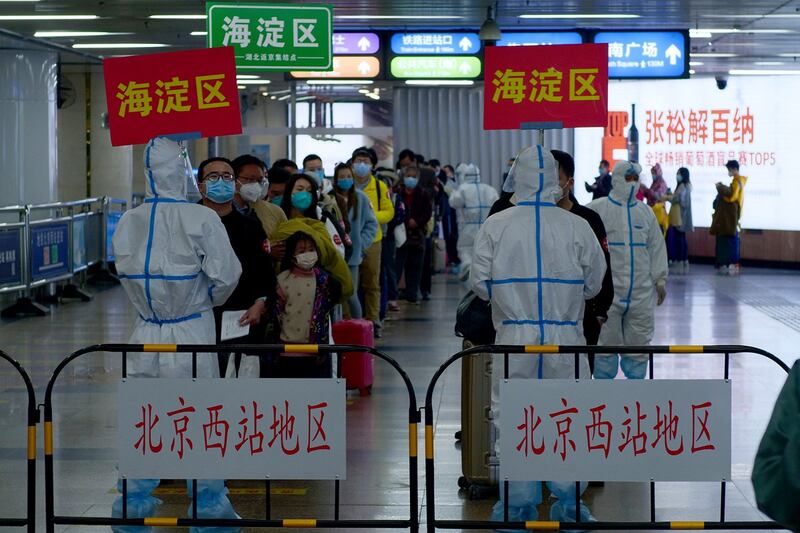 图为，来自武汉的乘客排队等候在北京隔离的地方。（AP）