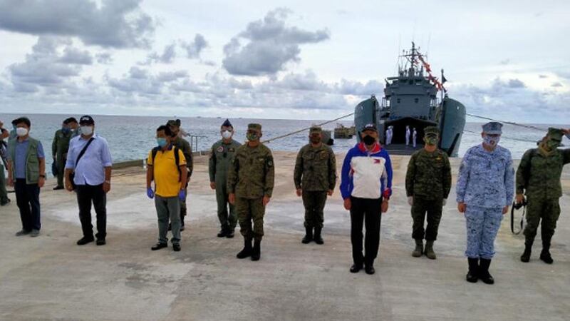 Philippine Defense Secretary Delfin Lorenzana (in white and blue jacket) joins defense officials as he inaugurates a beaching ramp on Pag-asa (Thitu) Island in the South China Sea, June 9, 2020.