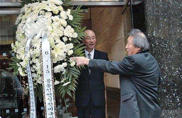2011년 11월20일 김정일 사망 후 분향소를 설치한 미국 뉴욕의 유엔주재 북한대표부 건물 앞에서 박철(왼쪽) 참사가 뉴욕의 한인으로부터 조화를 전달받고 있다. 