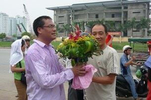 Anh Nguyễn Chí Đức (áo tím), nạn nhân của cú đạp lịch sử, nhận hoa từ người thân sau khi được công an thả hôm 17/7/2011