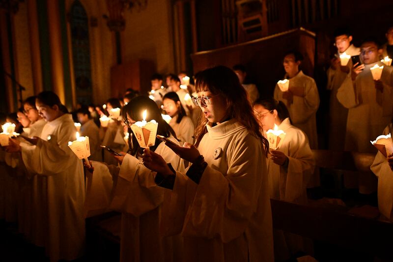 Catholic faithful and a Chinese choir sing hymns during an Easter mass at a church in Beijing on March 30, 2024.