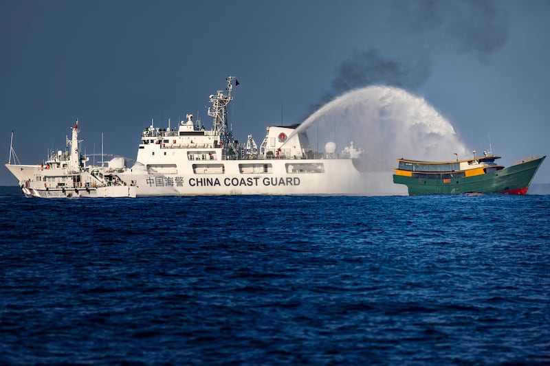 A Chinese Coast Guard ship fires a water cannon at Unaizah May 4, a Philippine Navy chartered vessel, conducting a routine resupply mission to troops stationed at Second Thomas Shoal, on March 5, 2024 in the South China Sea.