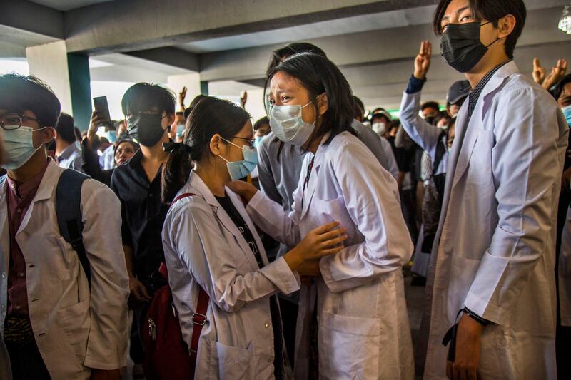 In this March 16, 2021 photo, medical students mourn as others flash the three-fingered salute at the funeral of a fellow medical student who was shot in the chest two days earlier by junta security forces during a protest against the military takeover in Yangon, Myanmar. Credit: AP Photo