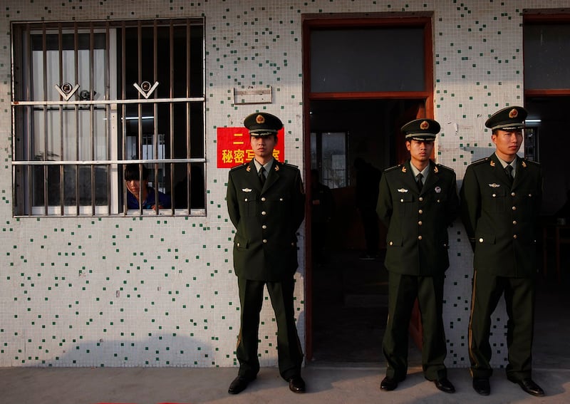 2012年2月1日的一次地方选举过后,广东省陆丰市乌坎村的警察在一处由学校教室改设的计票所外面站岗。(路透社资料图片)