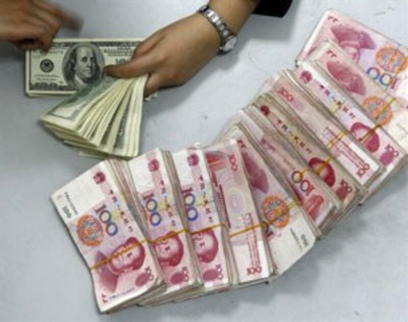 Một nhân viên ngân hàng đang xếp tiền đô la Mỹ và đồng nhân dân tệ của Trung Quốc tại một ngân hàng ở tỉnh Tứ Xuyên, Trung Quốc hôm 08/4/2010.