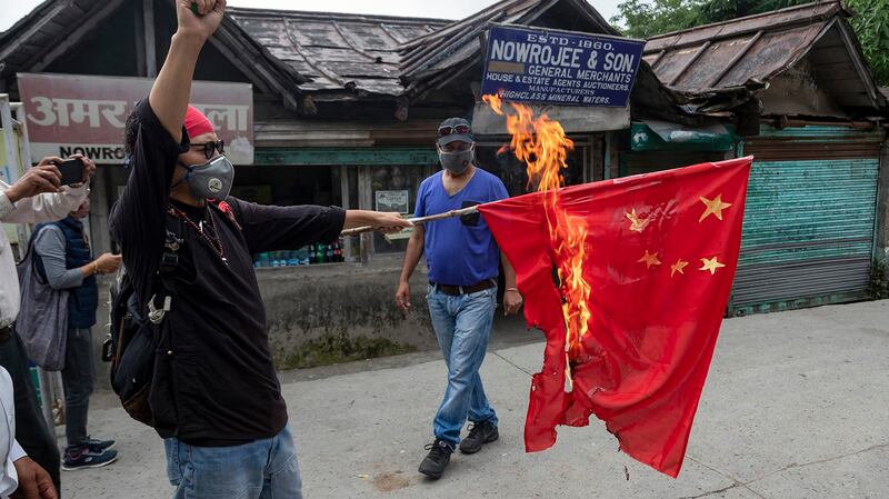 2020年6月18日，一名流亡藏人在印度达兰萨拉焚烧中国国旗抗议。（美联社）